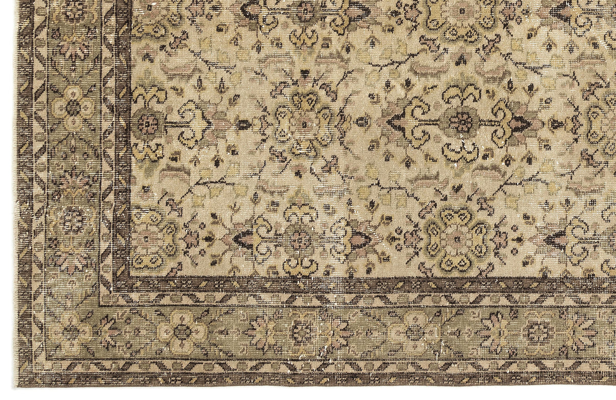 Beige and olive green traditional rug with a distressed floral medallion pattern and a dark brown geometric border.