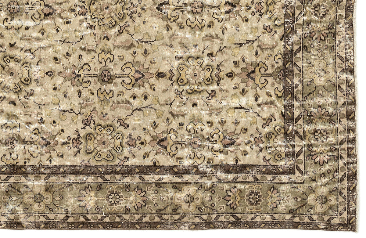 Distressed beige rug with a faded floral medallion pattern and a dark brown geometric border.