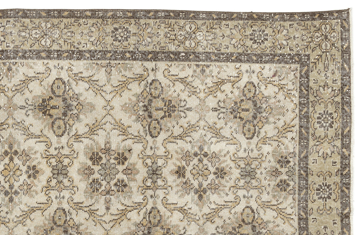 A close-up of the Sadeane - Vintage Floral Rug (6'0 X 9'8) featuring a faded beige, brown, and ivory floral pattern with a decorative border and a distressed antique look inspired by classic Anatolian heritage rugs.