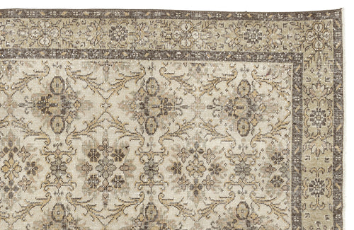Load image 1 in gallery view. A close-up of the Sadeane - Vintage Floral Rug (6'0 X 9'8) featuring a faded beige, brown, and ivory floral pattern with a decorative border and a distressed antique look inspired by classic Anatolian heritage rugs.