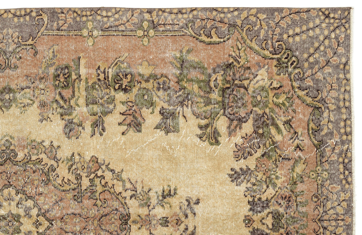 Distressed vintage-style rug with a floral medallion pattern in muted tones of beige, sage green, and charcoal gray.