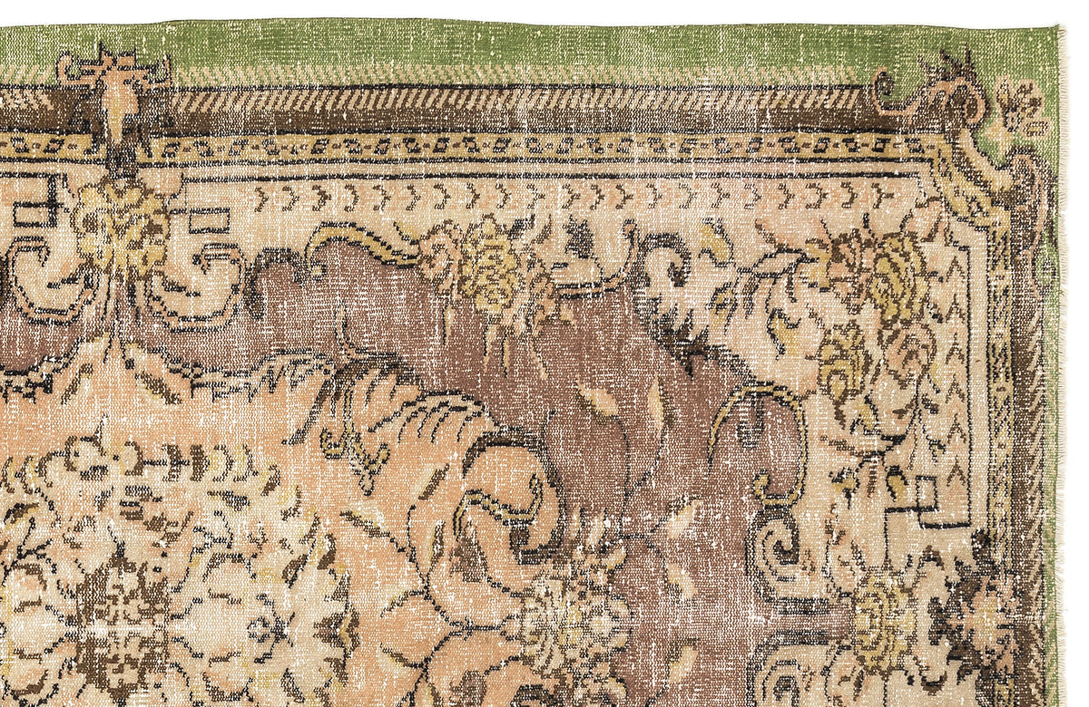 Distressed traditional rug with a green border and brown and beige floral medallion pattern on a white background.