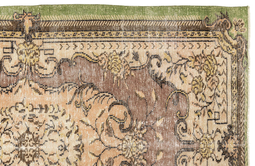 Load image 1 in gallery view. Distressed traditional rug with a green border and brown and beige floral medallion pattern on a white background.