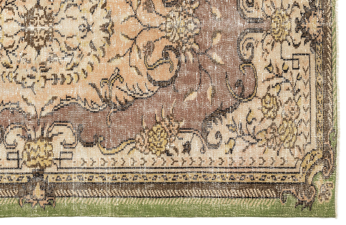 Distressed brown, beige, and green rug with a traditional floral medallion pattern and a decorative border.
