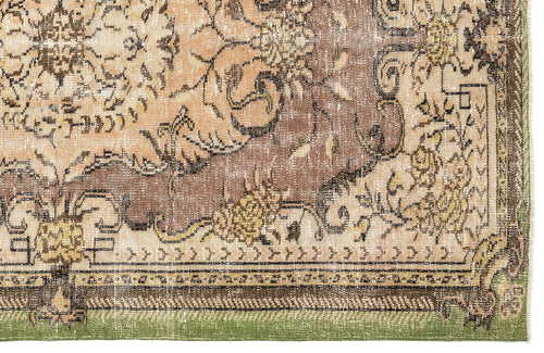 Load image 1 in gallery view. Distressed brown, beige, and green rug with a traditional floral medallion pattern and a decorative border.