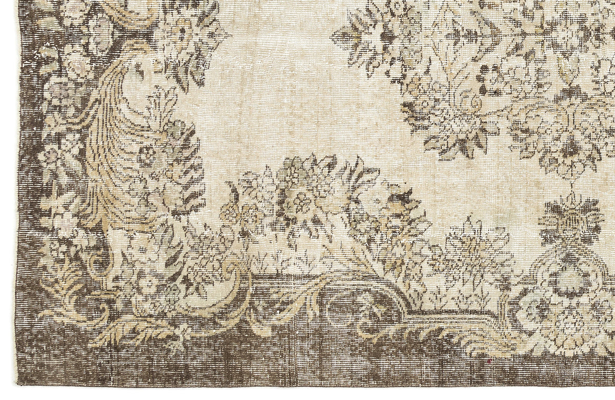 Beige and dark brown vintage-style rug with a distressed floral medallion pattern.
