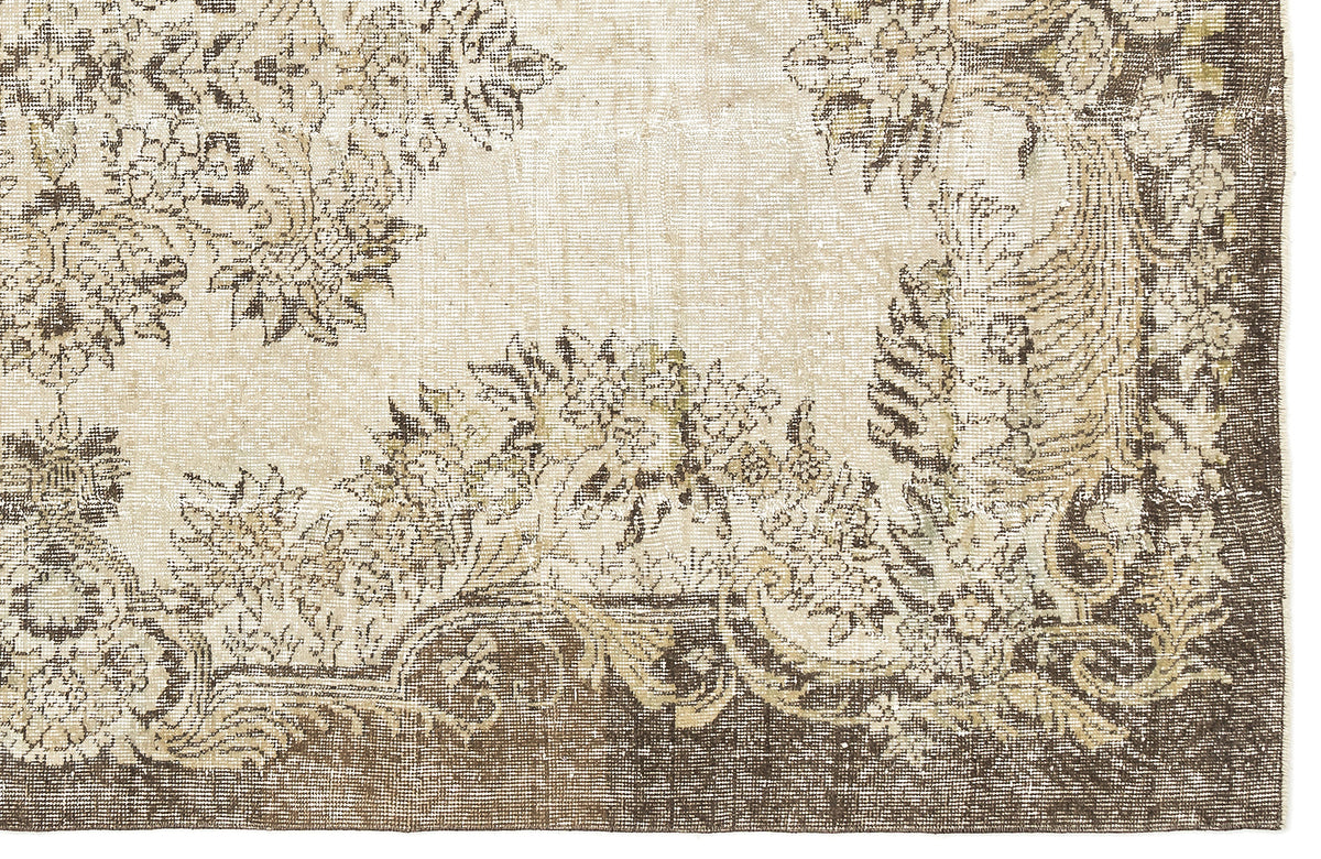 Beige and dark brown rug with a distressed, traditional floral medallion pattern.