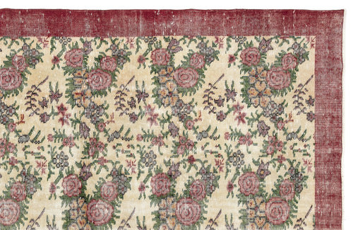 Load image 1 in gallery view. Distressed cream rug with a red border and a repeating floral pattern in shades of red, green, and dark grey.