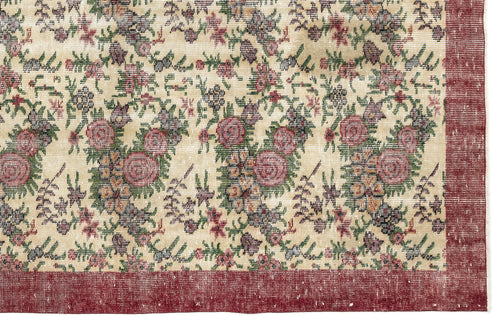 Load image 1 in gallery view. Cream rug with a distressed floral pattern in red, green, and purple, featuring a solid red border.