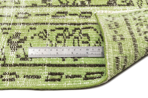 Load image 1 in gallery view. Light green rug with a dark brown distressed geometric pattern, shown with a metal ruler for scale.