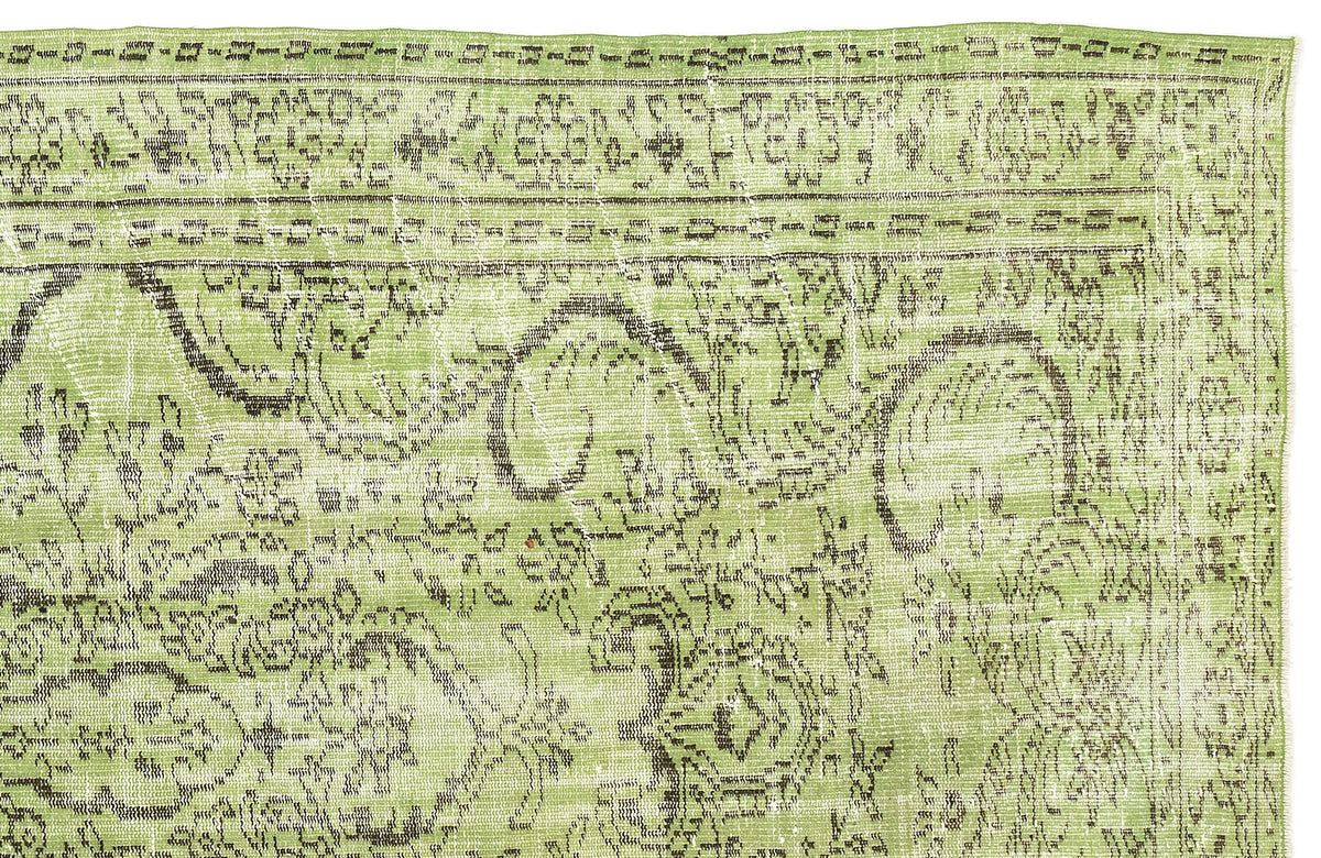 Light green distressed rug with a dark brown traditional floral medallion pattern on a white background.