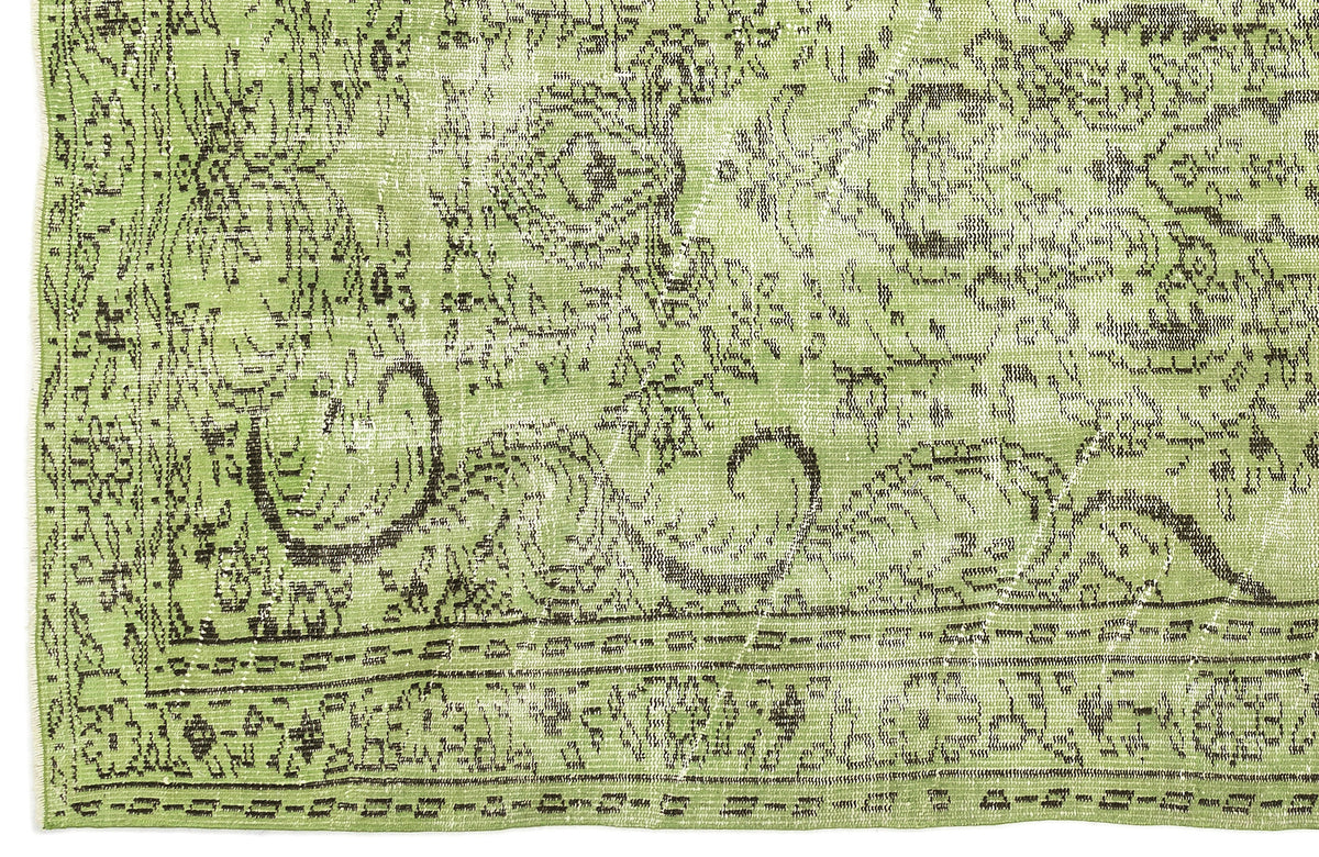 Sage green distressed rug with a dark brown traditional floral medallion pattern and a geometric border.