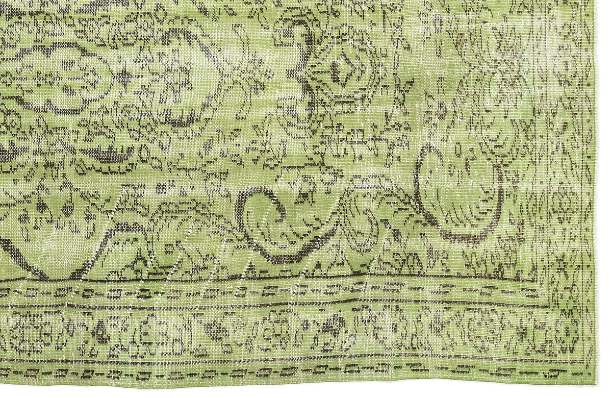 Sage green rug with a distressed, dark brown traditional floral medallion pattern and a decorative border.