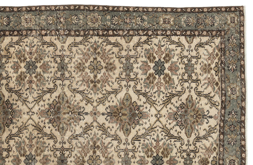 Load image 1 in gallery view. Distressed beige rug with a repeating floral medallion pattern in muted blue, brown, and grey on a white background.