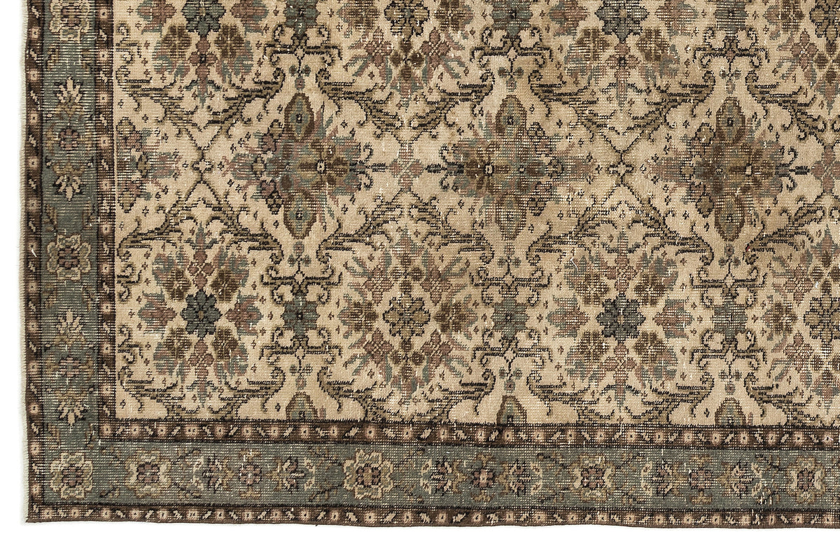 Beige, brown, and slate blue traditional rug with a distressed floral medallion pattern and a wide decorative border.