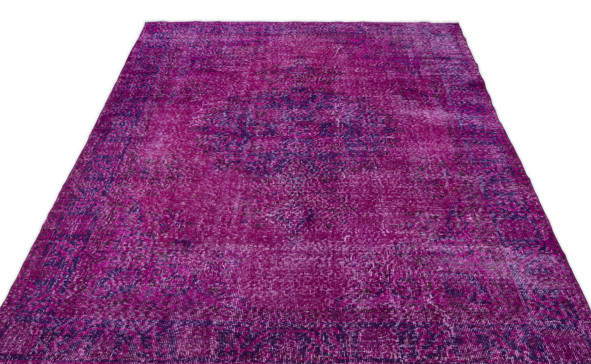 Magenta and deep purple distressed vintage-style rug with a central medallion pattern on a white background.