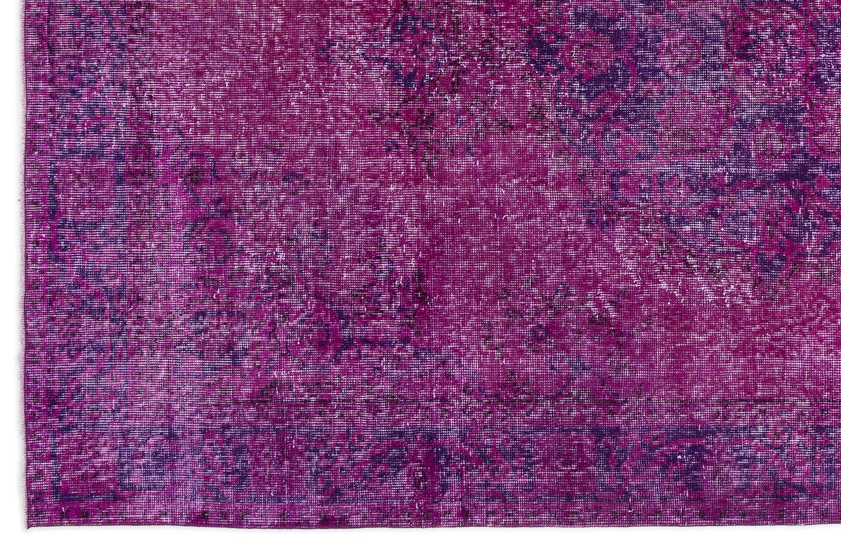 Magenta and deep purple distressed rug with a faded traditional medallion pattern.