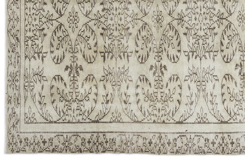 Load image 1 in gallery view. A close-up of the Greunoa - Vintage Floral Rug (5'4 x 9'6) showcases its intricate, symmetrical floral and vine pattern in beige and brown tones, detailed border design, and textured woven fabric for a charming vintage appeal.