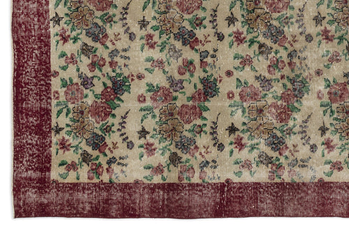 Load image 1 in gallery view. Beige rug with a distressed floral pattern in red, green, and blue, featuring a wide dark red border.