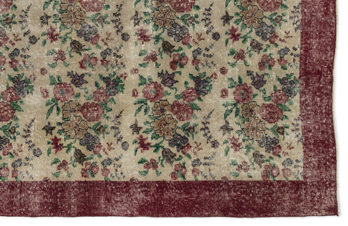 Load image 1 in gallery view. Beige rug with a distressed floral pattern in red, green, and purple, featuring a solid dark red border.