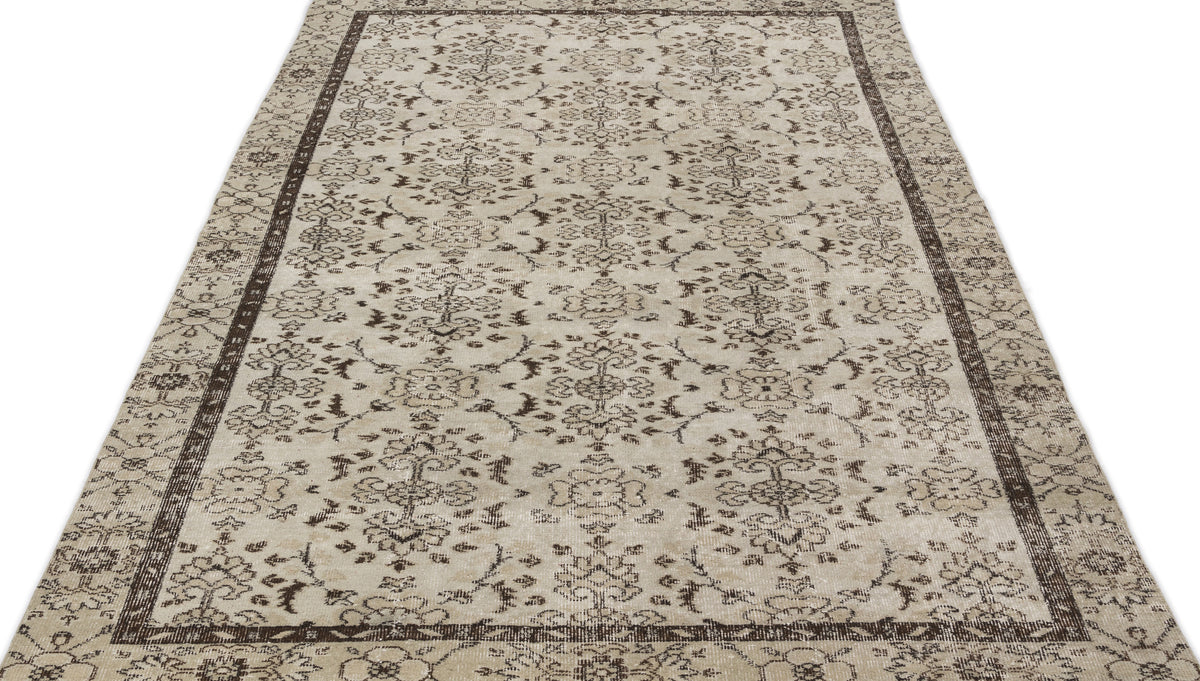 Beige and dark brown traditional rug with a distressed floral medallion pattern and a wide decorative border.