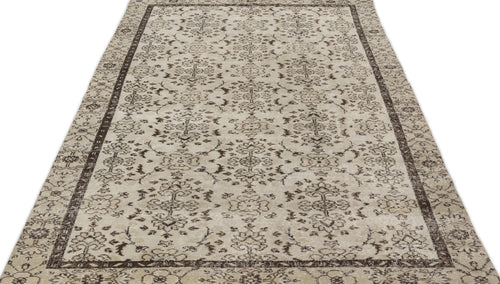 Load image 1 in gallery view. Beige and dark brown traditional rug with a distressed floral medallion pattern and a wide decorative border.