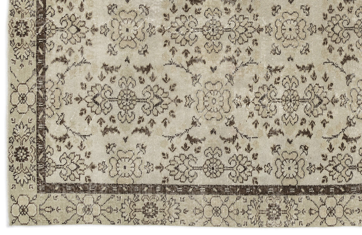 Beige and dark brown distressed rug with a traditional floral medallion pattern and a wide decorative border.