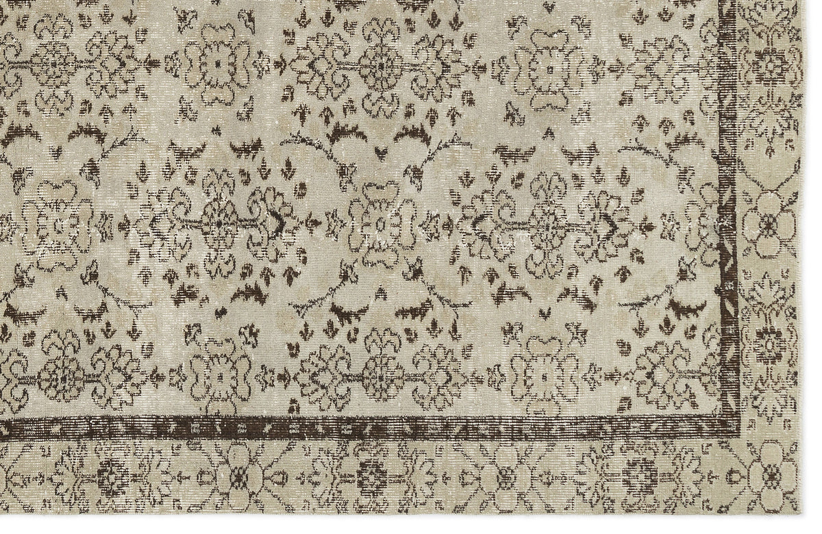 Beige and dark brown rug with a distressed floral medallion pattern and a decorative border.