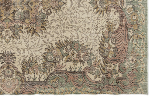 Load image 1 in gallery view. Beige rug with a distressed traditional floral and vine pattern in muted sage green, dusty rose, and brown.