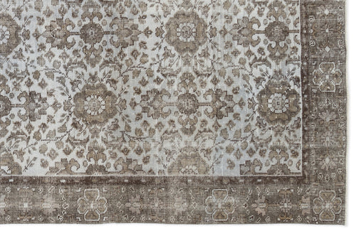 Load image 1 in gallery view. Brown and cream distressed rug with a traditional floral medallion pattern and a wide decorative border.