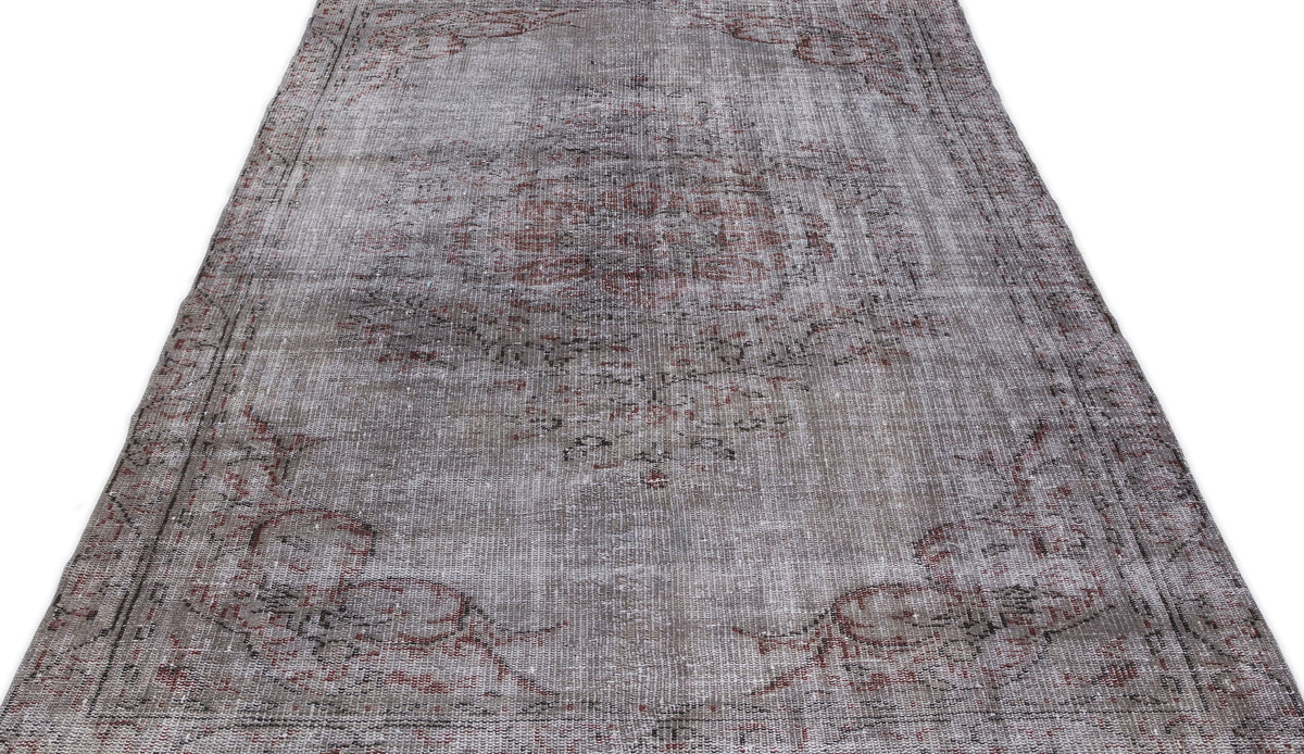 Distressed grey and faded red vintage-style rug with a central medallion and ornate border on a white background.