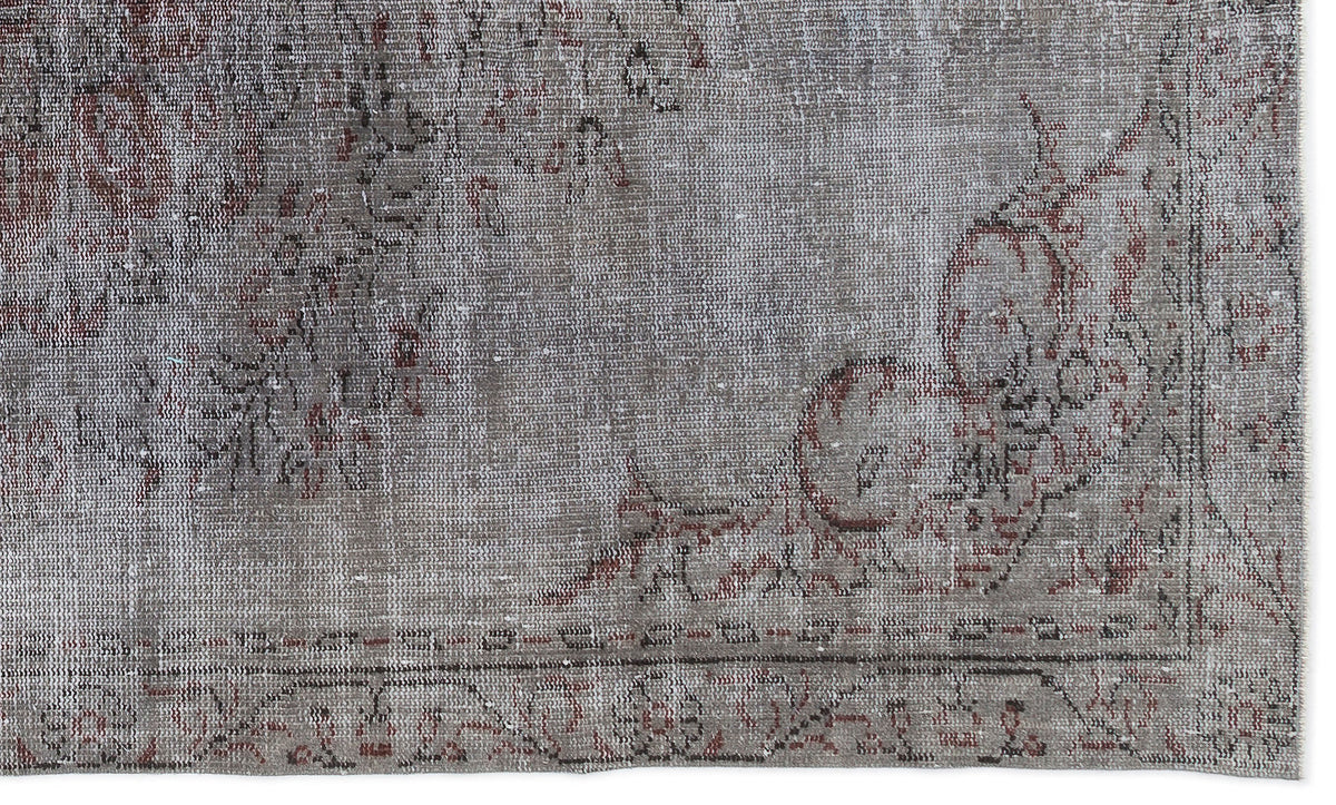 Distressed grey and faded red rug with a traditional floral medallion pattern and a bordered edge.