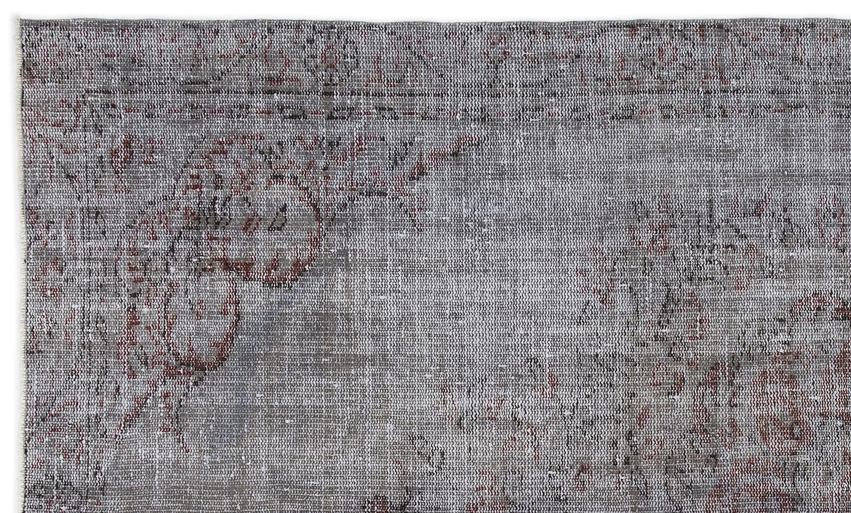 Grey and charcoal distressed rug with a faded traditional floral medallion pattern.