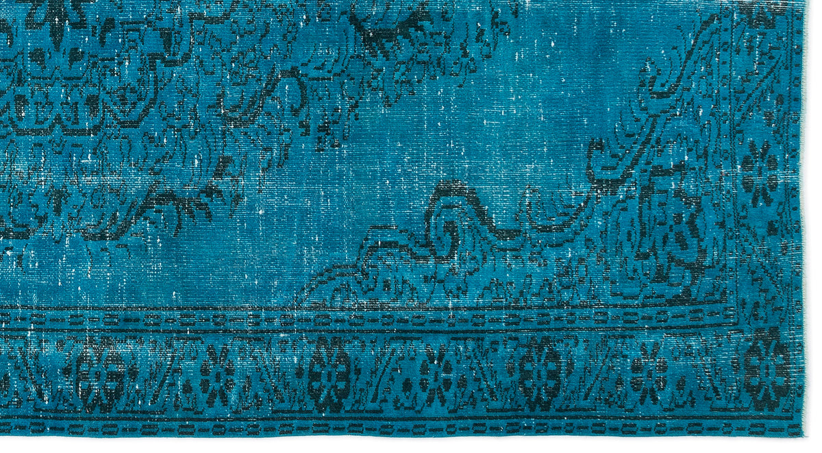 Teal and black distressed rug with a traditional ornate floral medallion pattern and a geometric border.