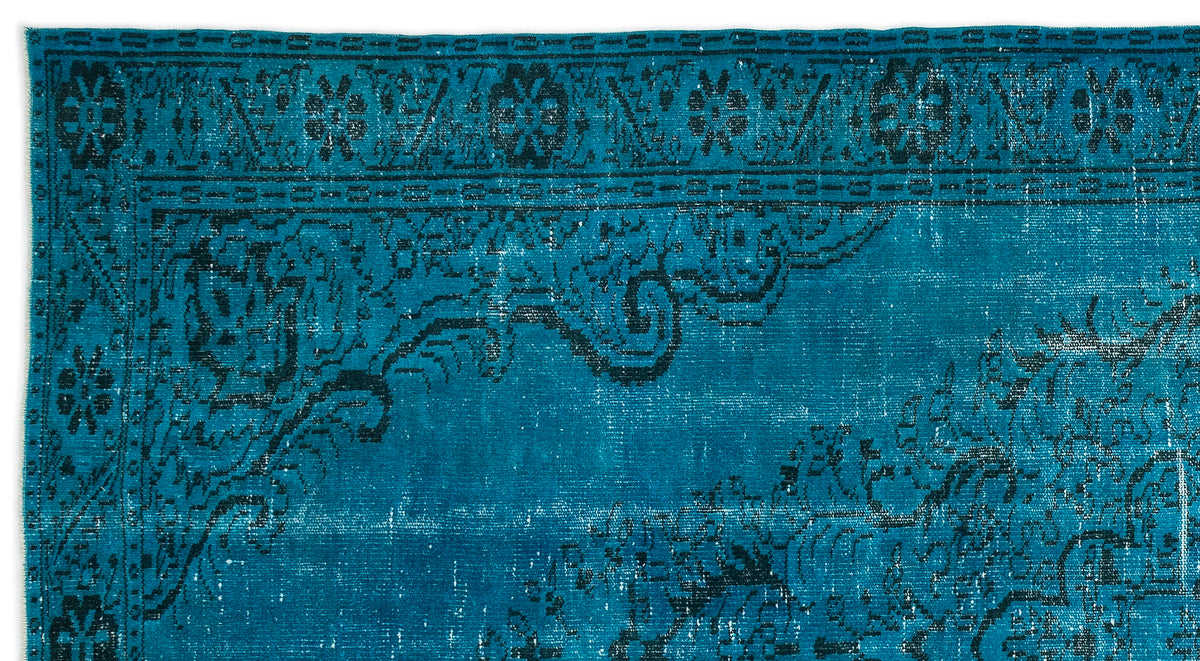 Teal rug with a distressed black traditional floral border and medallion pattern.