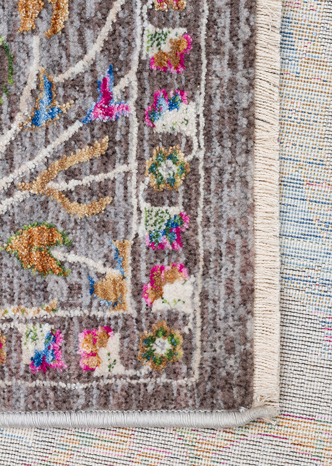 Grey rug with a floral border and fringe edge, featuring multicolored accents in pink, blue, and gold.