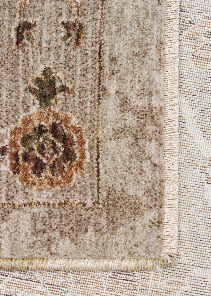 Beige and cream traditional rug with a distressed floral medallion pattern and fringed edge.