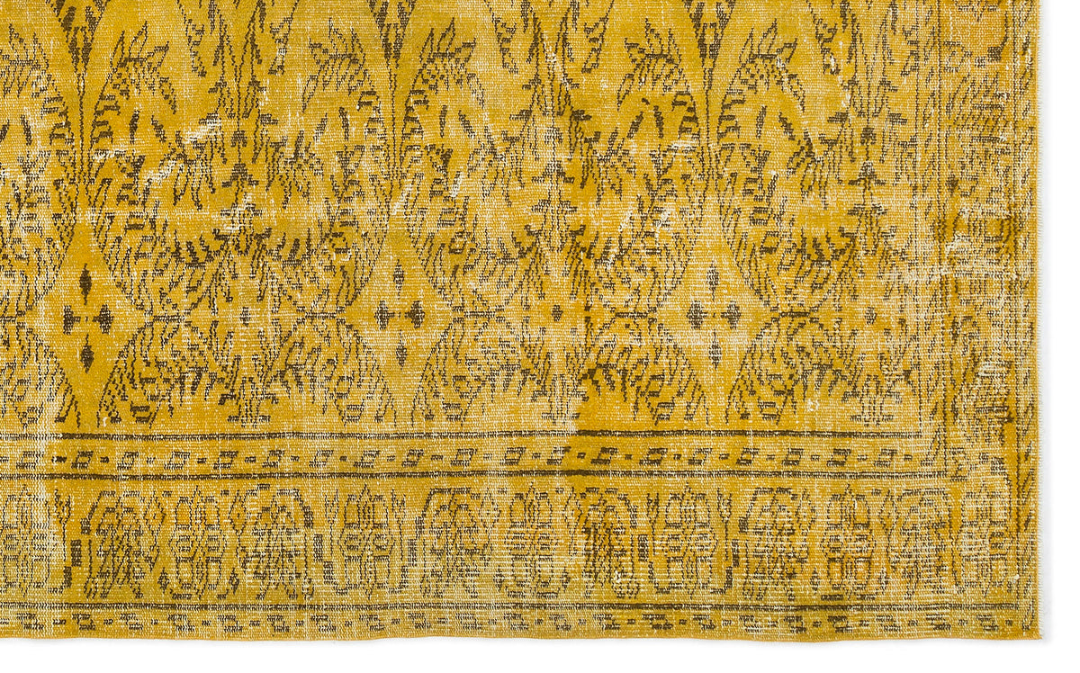 Mustard yellow and charcoal distressed rug with an ornate botanical medallion pattern and a geometric border.