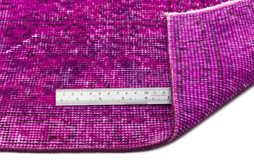 Load image 1 in gallery view. Magenta distressed rug with a dark floral pattern, shown folded with a metal ruler for scale.