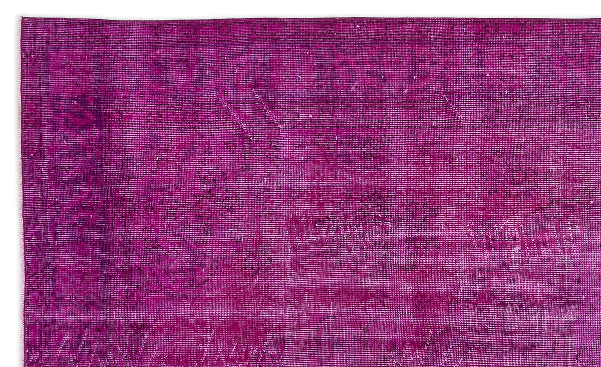 Magenta overdyed vintage rug with a faint, distressed traditional medallion pattern.