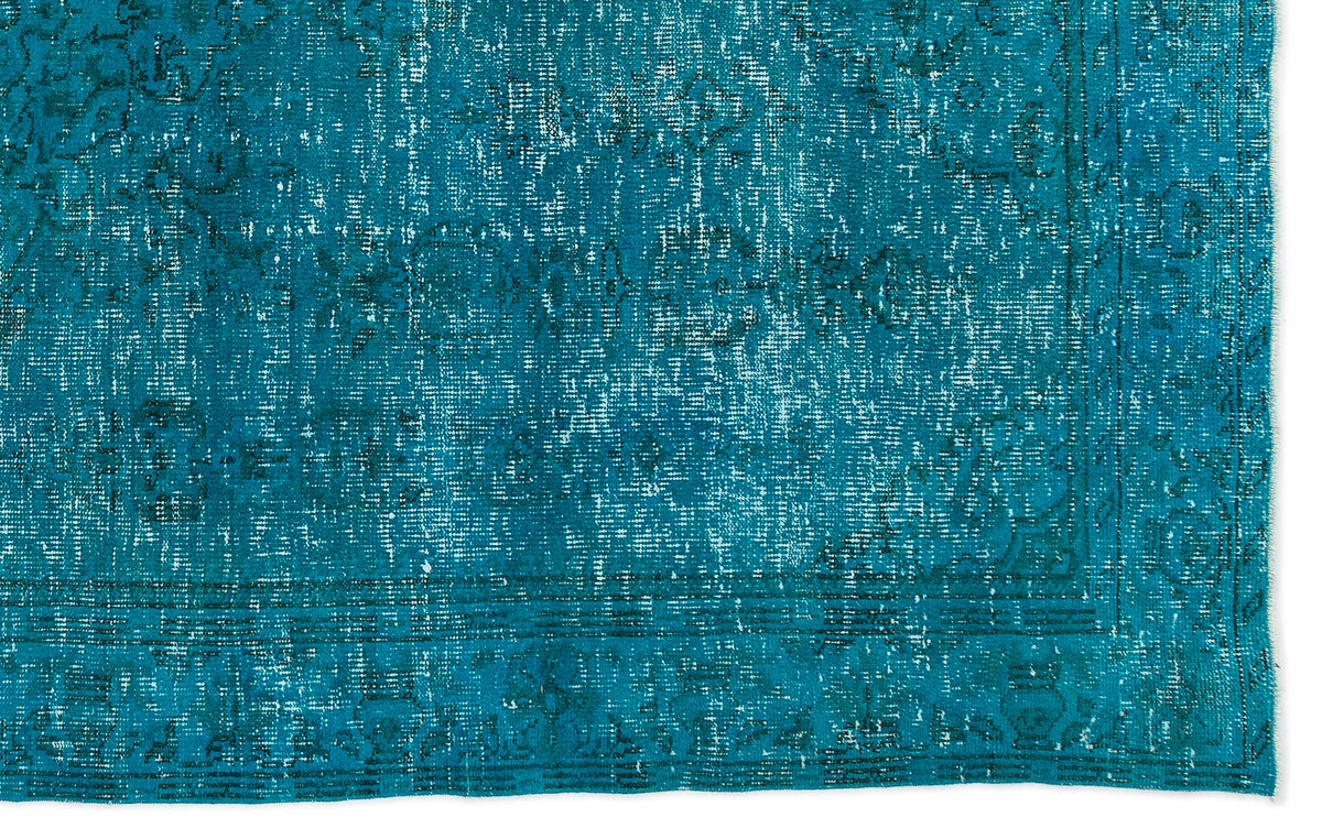 Teal distressed rug with a faded traditional medallion pattern and a bordered edge.