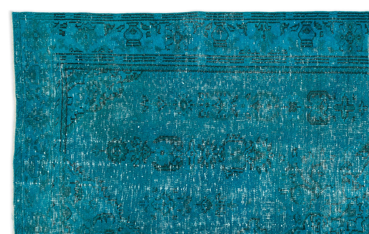 Teal distressed rug with a faded traditional border and central medallion pattern.