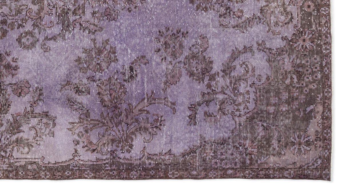 Lavender and dark brown distressed rug with a traditional floral medallion pattern.