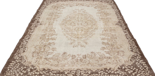 Load image 1 in gallery view. The Pririna Vintage Medallion Rug (6'2" x 9'7") features a long, rectangular shape with ornate beige and brown floral and medallion patterns, faded detailing, and a decorative border.