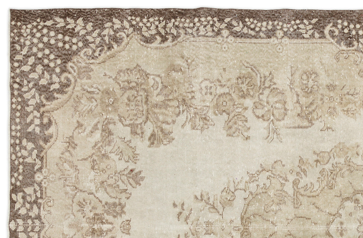 The Pririna Vintage Medallion Rug (6'2" x 9'7") features a faded floral and vine motif in beige, ivory, and brown with a decorative border, offering an antique, distressed look that adds character to any space.