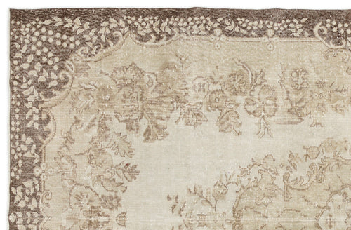 Load image 1 in gallery view. The Pririna Vintage Medallion Rug (6'2" x 9'7") features a faded floral and vine motif in beige, ivory, and brown with a decorative border, offering an antique, distressed look that adds character to any space.