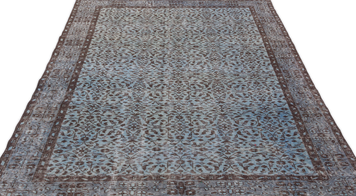 Distressed blue and brown vintage-style rug with an all-over floral pattern and a wide decorative border.