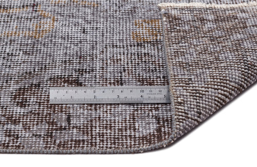 Load image 1 in gallery view. Grey and brown distressed traditional rug with a folded corner and a metal ruler for scale on a white background.