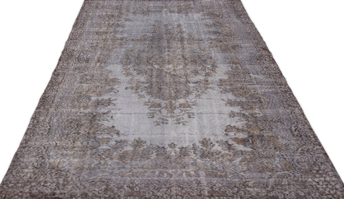 Load image 1 in gallery view. Grey and brown distressed vintage-style rug with a faded central floral medallion pattern on a white background.