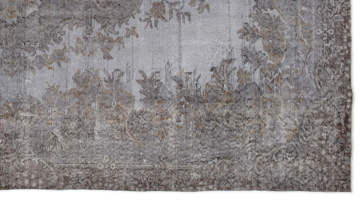 Grey and brown distressed rug with a faded traditional floral medallion pattern on a white background.